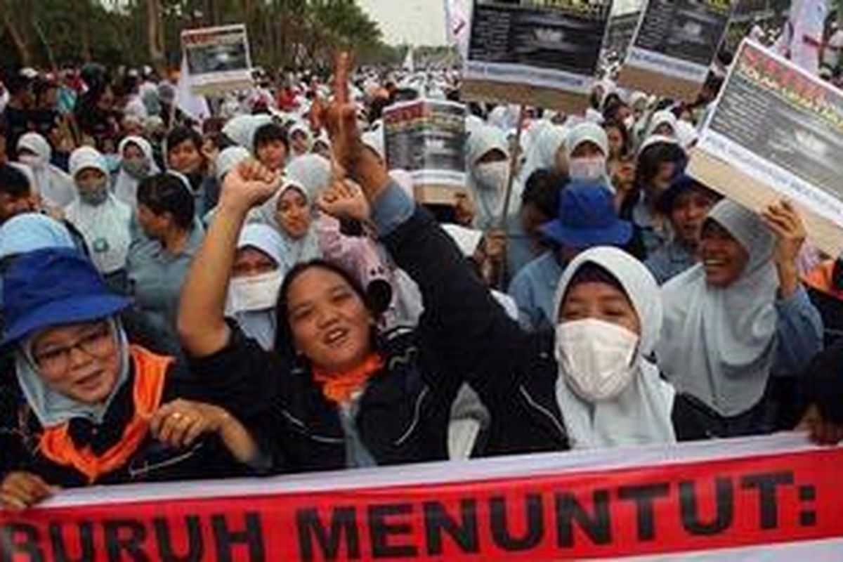 Buruh berunjuk rasa di kawasan industri MM 2100, Cikarang Barat, Bekasi, Jawa Barat, Rabu (3/10/2012). Dalam aksi yang dilakukan serentak di Jabodetabek ini, buruh menuntut agar pemerintah menghapuskan sistem kerja outsourcing, menaikkan upah buruh dan segera menjalankan jaminan sosial kepada buruh. 