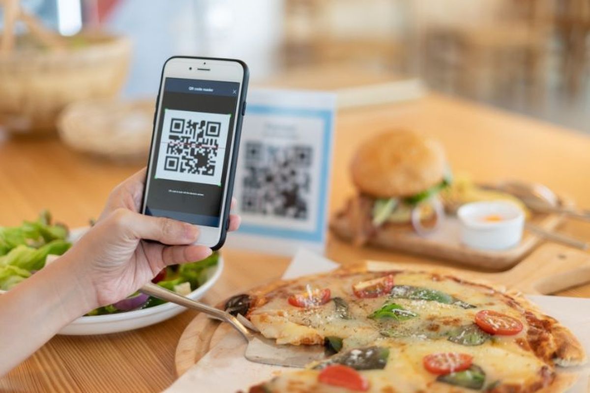 Ilustrasi orang membayar makanan dengan QR Code. 