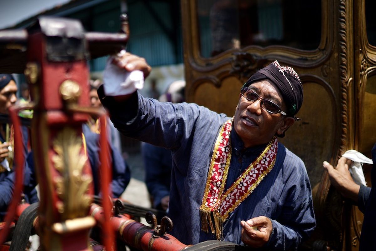 Potret Abdi Dalem yang bertugas melakukan Jamasan Pusaka berupa kereta milik Keraton Yogyakarta.
