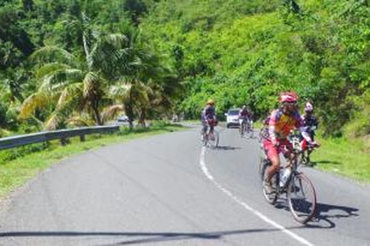 Peserta Kompas Jelajah Sepeda Manado-Makassar menempuh jalur menanjak di etape ketiga yaitu Lolak-Baroko sejauh sekitar 90 kilometer (km), Rabu (20/8/2014). 