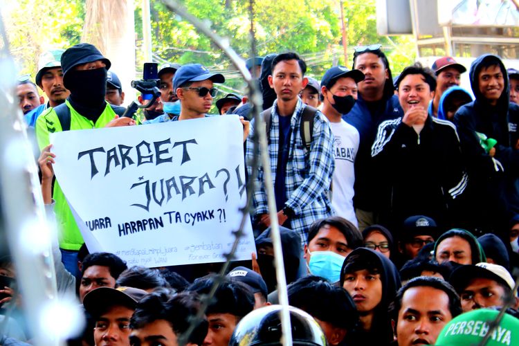 Salah seorang peserta aksi membawa tulisan yang dilakukan saat menggelar aksi demo kepada manajemen tim didepan kantor marketing Persebaya Surabaya yang berada di Sutos Surabaya, Jawa Timur, Senin (30/10/2023) pagi.