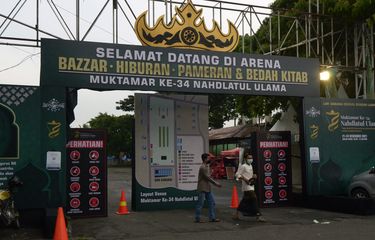 Pengunjung melintas di depan gapura pintu masuk Bazar, hiburan, dan pameran di Lapangan Saburai, Bandar Lampung, Lampung, Selasa (21/12/2021). Kegiatan bazar, pameran, hiburan, dan bedah kitab merupakan rangkaian dari acara Muktamar NU ke-34 di Provinsi Lampung. ANTARA FOTO/Ardiansyah/hp.