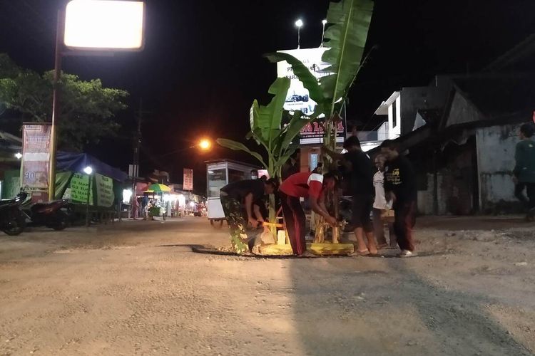 Warga Desa Talang Nganjuk menanam pohon pisang di Jalan Raya Talang Rejoso, Selasa (20/3/2021) malam. Aksi ini sebagai bentuk protes warga karena jalan tersebut rusak parah namun tak kunjung diperbaiki.