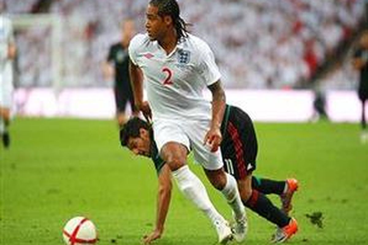 Defender Inggris, Glen Johnson, melewati pemain Meksiko, Carlos Vela. Johnson menyumbang satu gol dari kemenangan Inggris 3-1.