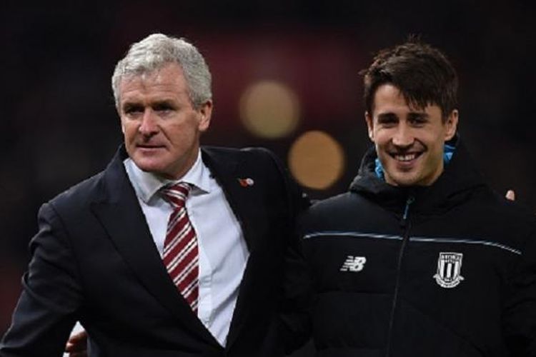 Manajer Stoke City, Mark Hughes (kiri), bersama pemainnya, Bojam Krkic, meninggalkan lapangan usai timnya sukses menekuk Chelsea 1-0 pada lanjutan Premier League di Stadion Britannia, Sabtu (7/11/2015).