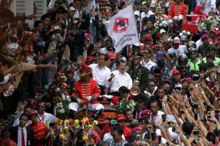 Presiden Joko Widodo dan Wakil Presiden Jusuf Kalla (Jokowi-JK), menaiki kereta kencana melintas di Jalan MH Thamrin, Jakarta Pusat, Senin (20/10/2014). Kirab yang merupakan rangkaian dari acara Syukuran Rakyat Salam 3 Jari, ini digelar usai pelantikan pasangan tersebut. Jokowi-JK diarak melintasi pusat Ibu Kota menuju Istana Negara.