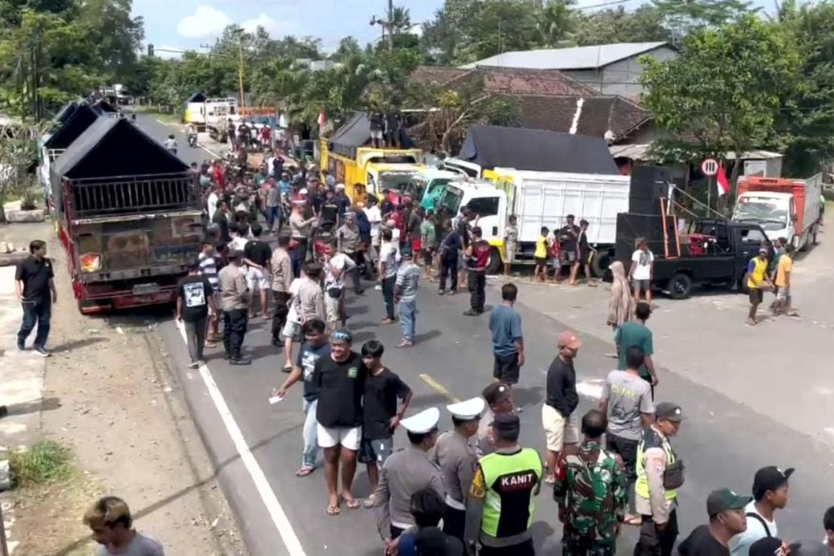 Suasana tegang terjadi selama demo penolakan kebijakan zero ODOL di Kecamatan Selorejo, Kabupaten Blitar, saat aparat keamanan meminta peserta aksi membuka blokir jalan, Kamis (19/6/2025)