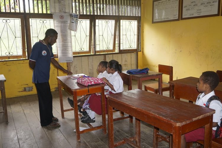 Guru honorer Melki Wally terlihat serius memberikan arahan terkait kegiatan belajar mengajar, kepada beberapa siswa kelas 1 di SD YPPK Ubrub, Kampung Umuaf, Distrik Web, Kabupaten Keerom, Papua, Senin (25/9/2023).