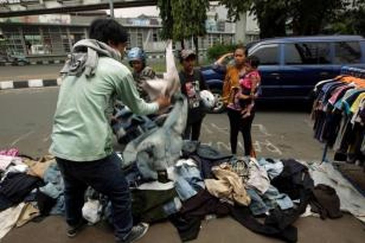 Pedagang Pasar Senen menggelar dagangannya di pinggir jalan Pasar Senen, Jakarta, Selasa (29/4/2014). Mereka terpaksa menjual murah sisa barang dagangan yang berhasil diselamatkan dari kebakaran yang melahap kios mereka.