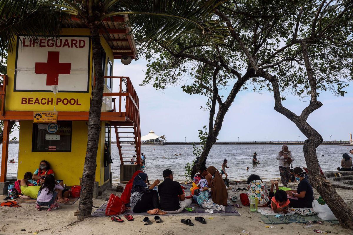 Pengunjung menikmati wisata pantai Lagoon di Taman Impian Jaya Ancol, Jakarta Utara, Kamis (29/10/2020). Liburan panjang dimanfaatkan warga untuk berwisata ke tempat wisata pantai tersebut, jumlah pengunjung tercatat mencapai sekitar 22.000 pada pukul 15.00. Kuota pengunjung dibatasi 25 persen dari kapasitas maksimal atau 25.000 orang pada masa pembatasan sosial berskala besar (PSBB) transisi ini.