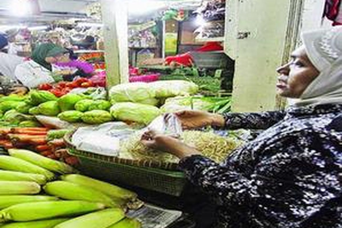 Pedagang melayani pembeli di kios bumbu dan sayur di Pasar Mayestik, Jakarta Selatan, Jumat (21/8). 