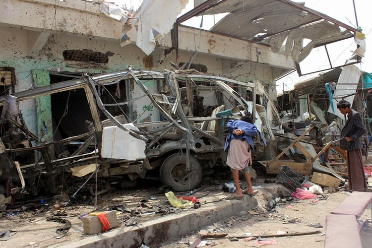 Warga melihat kondisi bus yang hancur akibat serangan yang dilancarkan pasukan koalisi pimpinan Arab Saudi di Yaman.