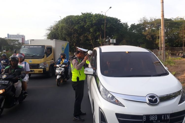 Petugas kepolisian menghentikan pengendara mobil yang melanggar sistem ganjil-genap di Jalan Benyamin Sueb, Senin (8/10/2018).
