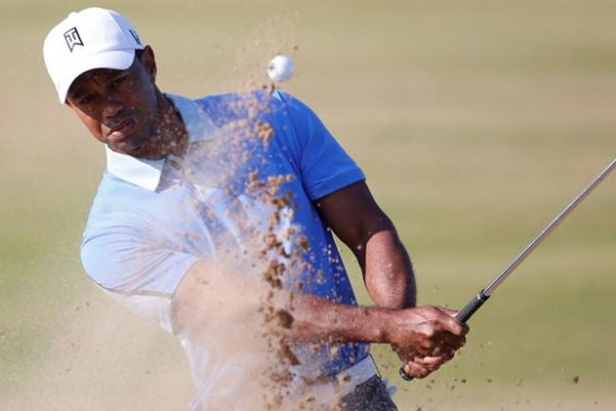 Pegolf Amerika Serikat, Tiger Woods memukul bola keluar dari bunker, saat berlatih jelang The Open Championship di Muirfield, Skotlandia, Rabu (17/7/2013).