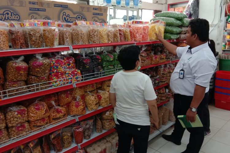 Kepala Badan POM Mimika Herianto Baan saat memeriksa produk makanan dalam kemasan plastik yang dijual di Toko Raihan, Rabu (19/12/2018)