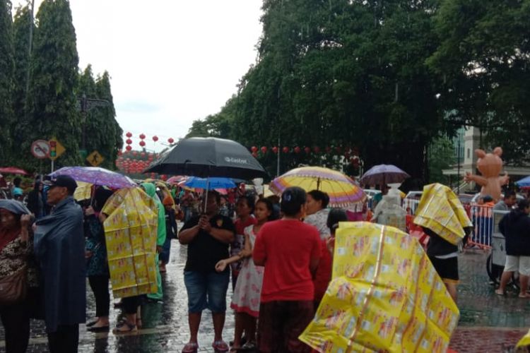 Plastik kemasan makanan ringan seperti yang dijual Jumali, banyak dipakai pengunjung Gtebeg Sudiro sebagai jas hujan atau payung darurat di tengah hujan yang mengguyur.