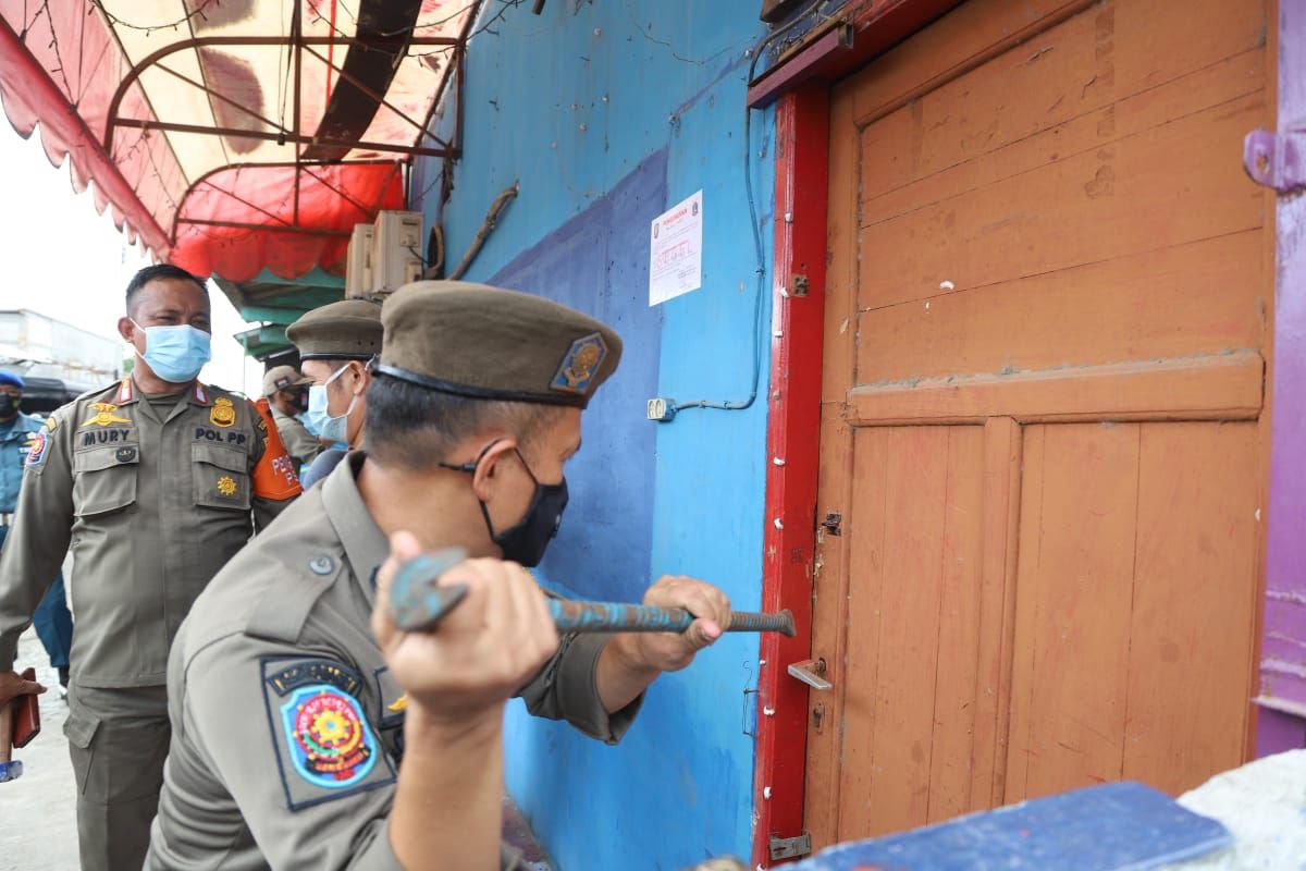 Petugas gabungan yang terdiri dari Satpol PP, TNI-Polri menyegel 25 kafe ilegal yang berdiri di atas lahan milik Pemerintah Provinsi DKI Jakarta, tepatnya di Jalan Inspeksi kali Cakung Drain dan Kali Gendong, Cilincing, Jakarta Utara pada Senin (21/12/2020).