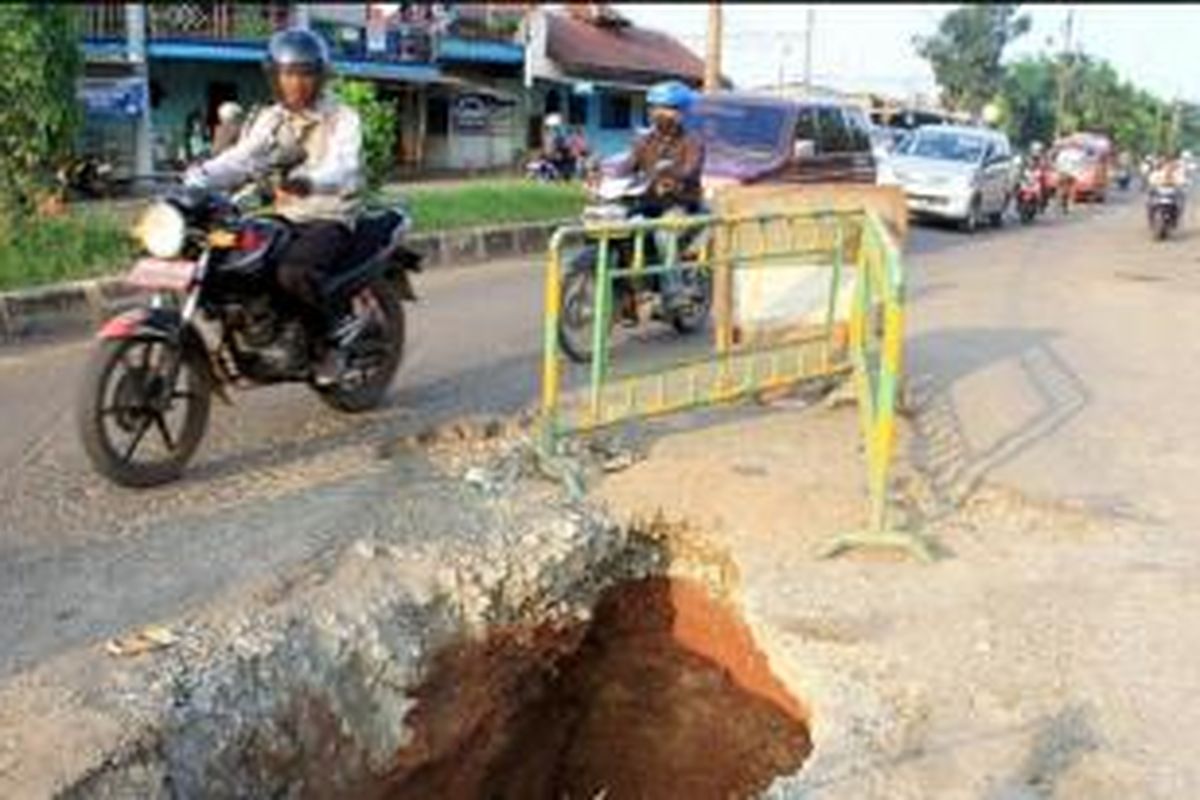 Jalan rusak dengan lubang menganga tampak di Jalan I Gusti Ngurah Rai, Bintara, Kecamatan Bekasi Barat, Kota Bekasi, Jawa Barat, Kamis (16/4). Pengendara dan warga setempat mengeluhkan kerusakan jalan yang tidak kunjung diperbaiki tersebut./KOMPAS/HARRY SUSILO