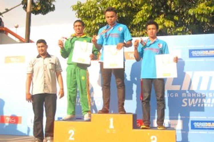 Perenang STKIP Bandung, M. Idham Dasuki (tengah), memamerkan medali emas yang didapat setelah memenangi nomor 100 meter gaya dada, pada Liga Mahasiswa (LIMA) Swimming 2013, di Kolam Renang Pertamina, Simprug, Jakarta Selatan, Minggu (30/6/2013) 