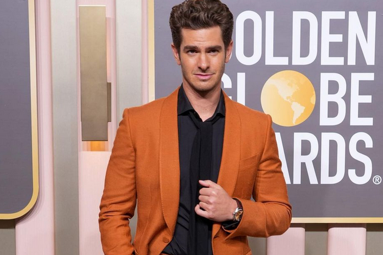 Andrew Garfield hadir mengenakan setelan berwarna orange yang selaras dengan jam tangannya, di Golden Globe 2023