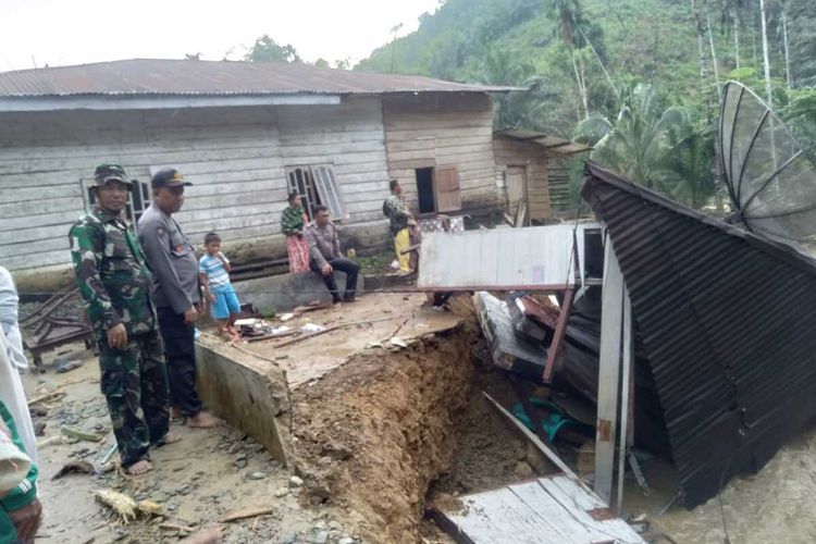 Personel TNI-Polri melihat rumah yang rusak berat akibat banjir bandang di Dusun Siria-ria A dan B, Desa Pematang dan Desa Hatapang, Kecamatan NA IX-IX, Labuhan Batu Utara, Minggu (29/12/2019) dini hari. Hingga siang tadi, tercatat 5 orang dalam satu keluarga belum ditemukan dan 9 rumah hanyut.