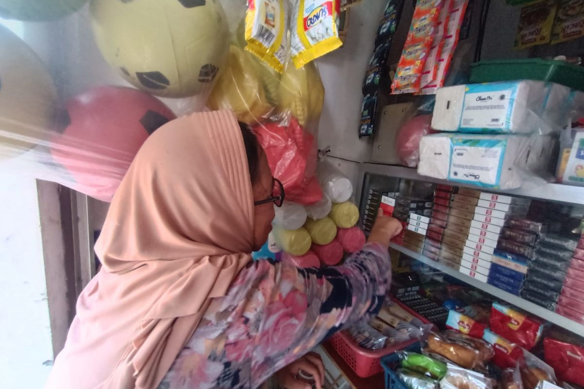 Maryani (47), pemilik warung, menunjukkan lokasi maling mencuri 15 bungkus rokok dari etalase miliknya pada Sabtu (2/9/2023) malam, Cakung, Jakarta Timur, Senin (4/9/2023).