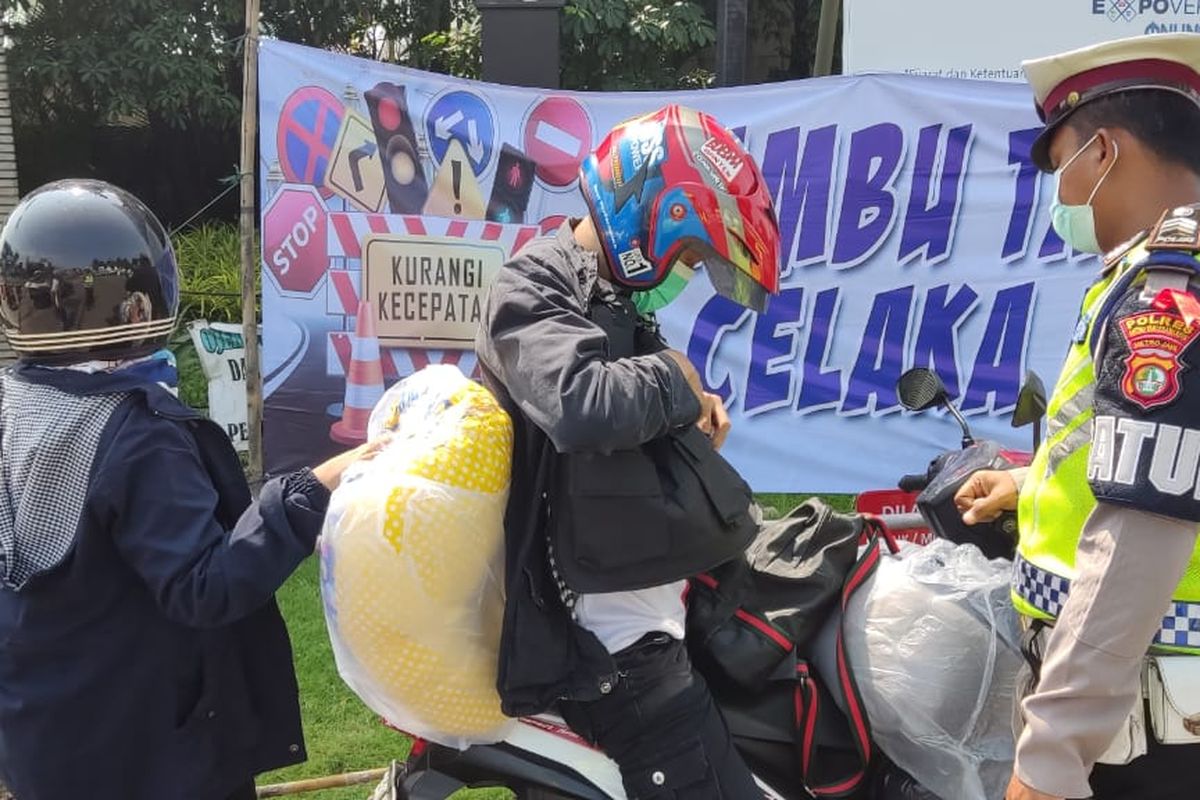Kepolisian saat menyekat salah satu pengendara motor yang hendak mudik di posko penyekatan yang berada di Jalan Gatot Subroto, Jatiuwung, Kota Tangerang, pada hari keempat larangan mudik Lebaran 2021, Minggu (9/5/2021).