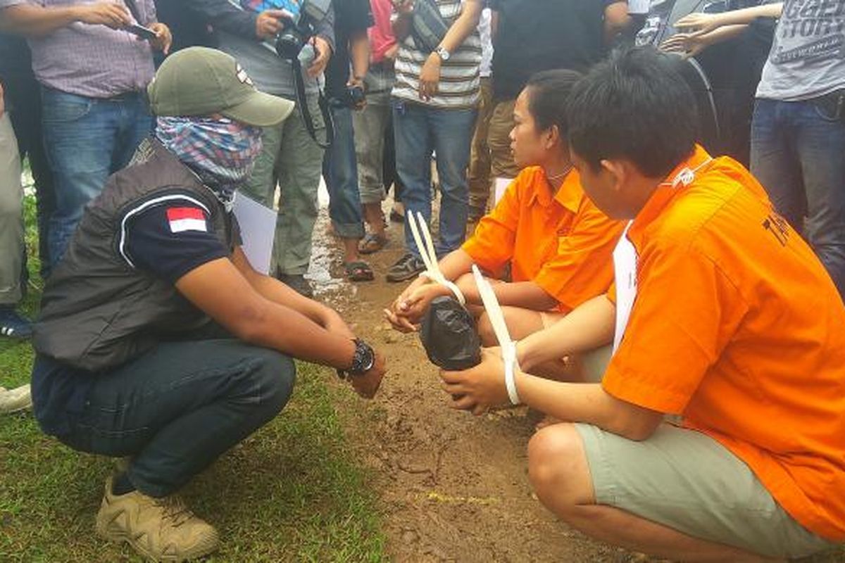 Tersangka pembunuhan Deston Sidabutar, pasangan suami istri Komeng (32) dan Desy Ratna (25) saat rekonstruksi di pematang sawah di Cikarang Utara, Bekasi, Jawa Barat, Senin (20/2/2017).