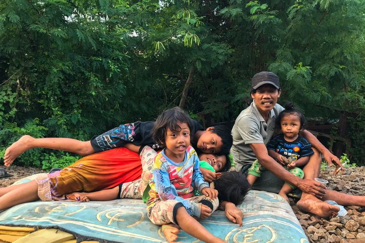 Keluarga Waluyo bercengkerama sambil menghabiskan sore hari di pinggir rel kereta Manggarai-Cikarang tepatnya di kawasan Manggarai, Tebet, Jakarta Selatan pada Jumat (13/3/2021) sore. Keluarga Waluyo merupakan potret keluarga yang termarjinalkan di ibu kota.