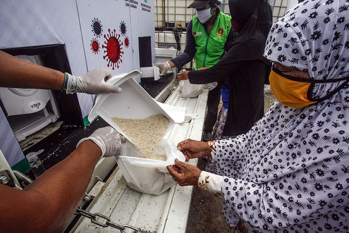 Relawan menuangkan beras gratis di ATM beras keliling Bogor Gercep di Desa Bojong Nangka, Gunung Putri, Bogor, Jawa Barat, Kamis (23/4/2020). Kegiatan tersebut guna meringankan beban ekonomi warga terdampak COVID-19 di wilayah Kabupaten Bogor.