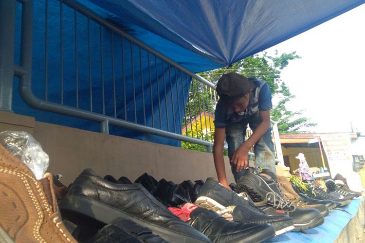 Fadiel, mengatur sepatu monja dagangannya di depan Kantor Imigrasi, Kota Lhokseumawe, Aceh, Sabtu (17/3/2018)