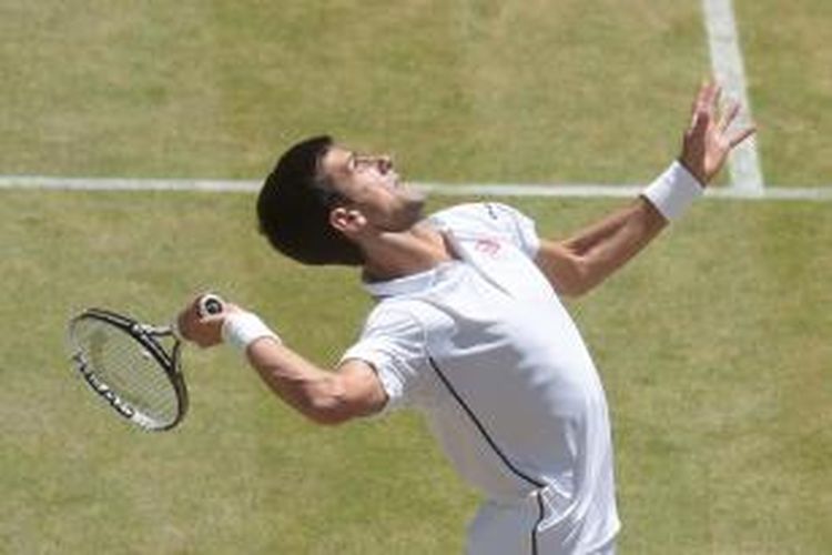 Petenis Serbia, Novak Djokovic, melakukan servis saat menghadapi petenis Bulgaria, Grigor Dimitrov, pada laga semifinal Wimbledon di London, Jumat (4/7/2014).