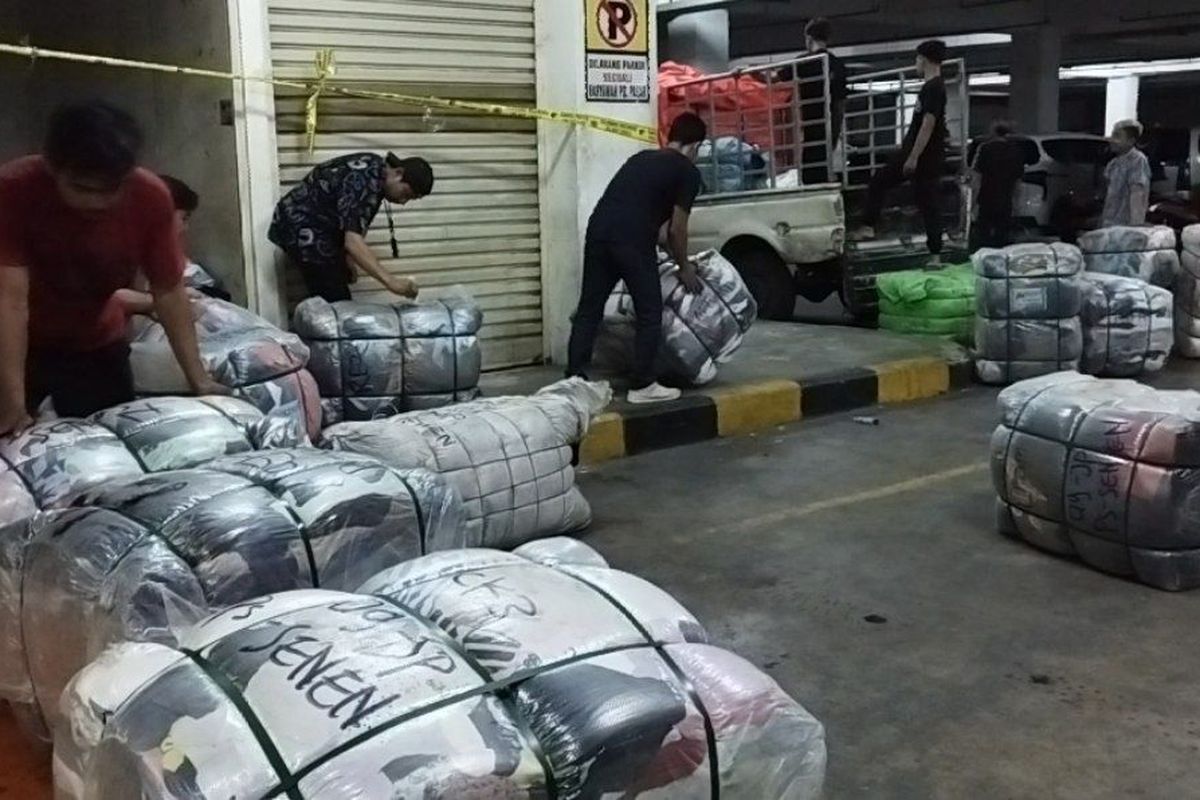 Petugas melakukan pembongkaran gudang baju bekas impor alias thrift di Pasar Senen Blok III, Senen, Jakarta Pusat, Senin (20/3/2023) malam. (KOMPAS.com/XENA OLIVIA)