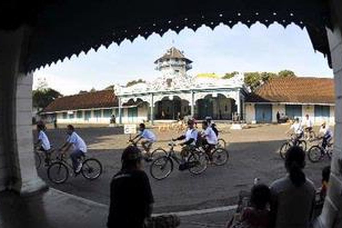 Sejumlah warga melihat penggemar sepeda dari beragam komunitas sepeda yang melintasi Kompleks Keraton Kasunanan Surakarta saat menyemarakkan sepeda gembira yang digelar oleh Harian Kompas di Solo, Jawa Tengah, Minggu (27/6/2010). 
