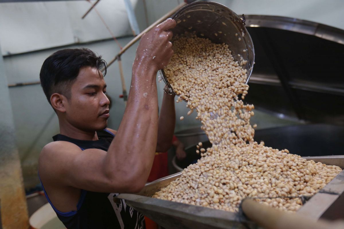 Pengrajin membuat tempe di kawasani pabrik tahu dan tempe Kalideres, Jakarta Barat, Rabu (19/9/2018). Pengrajin tempe dan tahu  mengadu terkait kenaikan dolar yang hampir menyentuh angka Rp 15.000 ke hadapan Menteri Perdagangan Enggartiasto Lukita.