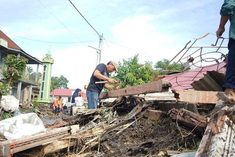 Jhoni Wismar bersama saudaranya sedang memisahkan trali besi dari Kunsen jendela, yang merupakan puing dari rumahnya setelah habis dihantam banjir di Galuang, Sungai Puar, Agam, Sumatera Barat, Selasa (14/5/2024).