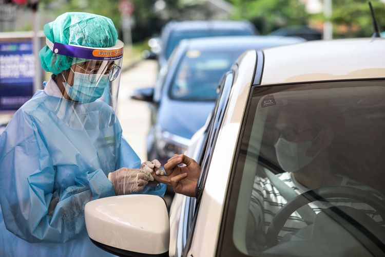 Tenaga medis dari Siloam Hospitals Group melakukan uji cepat (rapid test) kepada warga dengan skema drive thru di Jalan Puri Abadi, Kembangan, Jakarta Barat, Sabtu (18/4/2020). Uji cepat ini dilakukan dalam upaya mendukung usaha pemerintah menekan laju penyebaran wabah Covid-19.