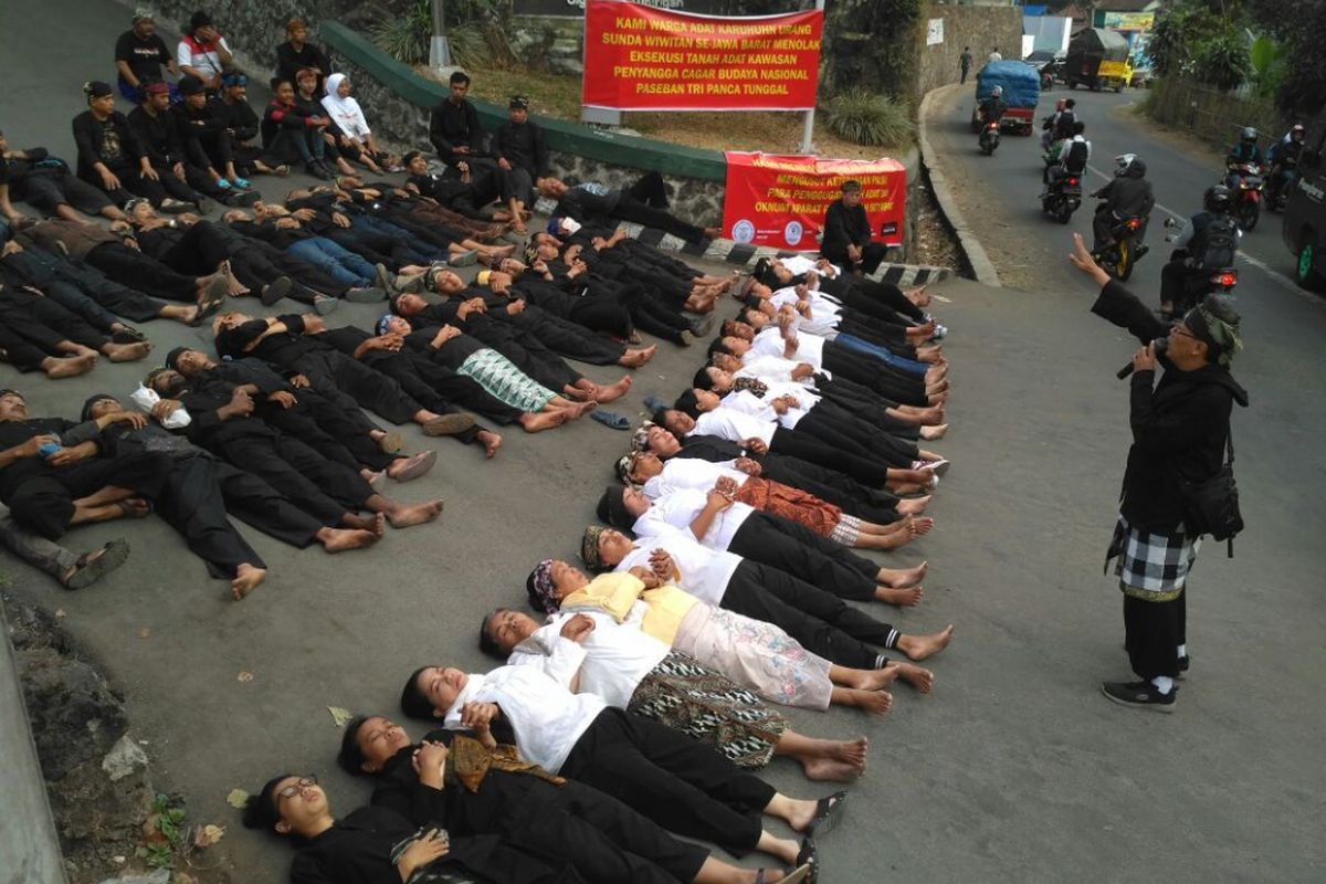 Puluhan warga adat Karuhun Urang Sunda Wiwitan Cigugur melakukan aksi tidur di jalan menuju lokasi eksekusi, di Desa Cigugur, Kecamatan Cigugur, Kabupaten Kuningan, Jawa Barat, Kamis pagi (24/8/2017).