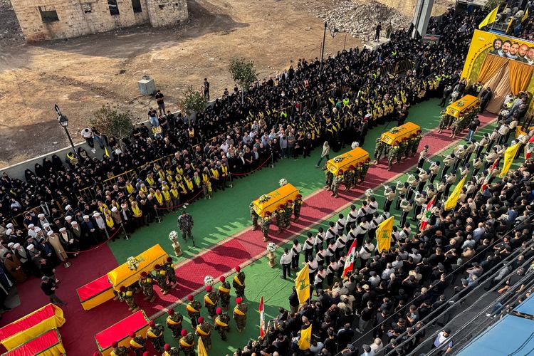 Prajurit Hizbullah membawa peti mati berisi sesama anggota yang tewas dalam serangan Israel, ketika melakukan pemakaman di Nabatiyeh, Lebanon, Minggu (2/11/2025).