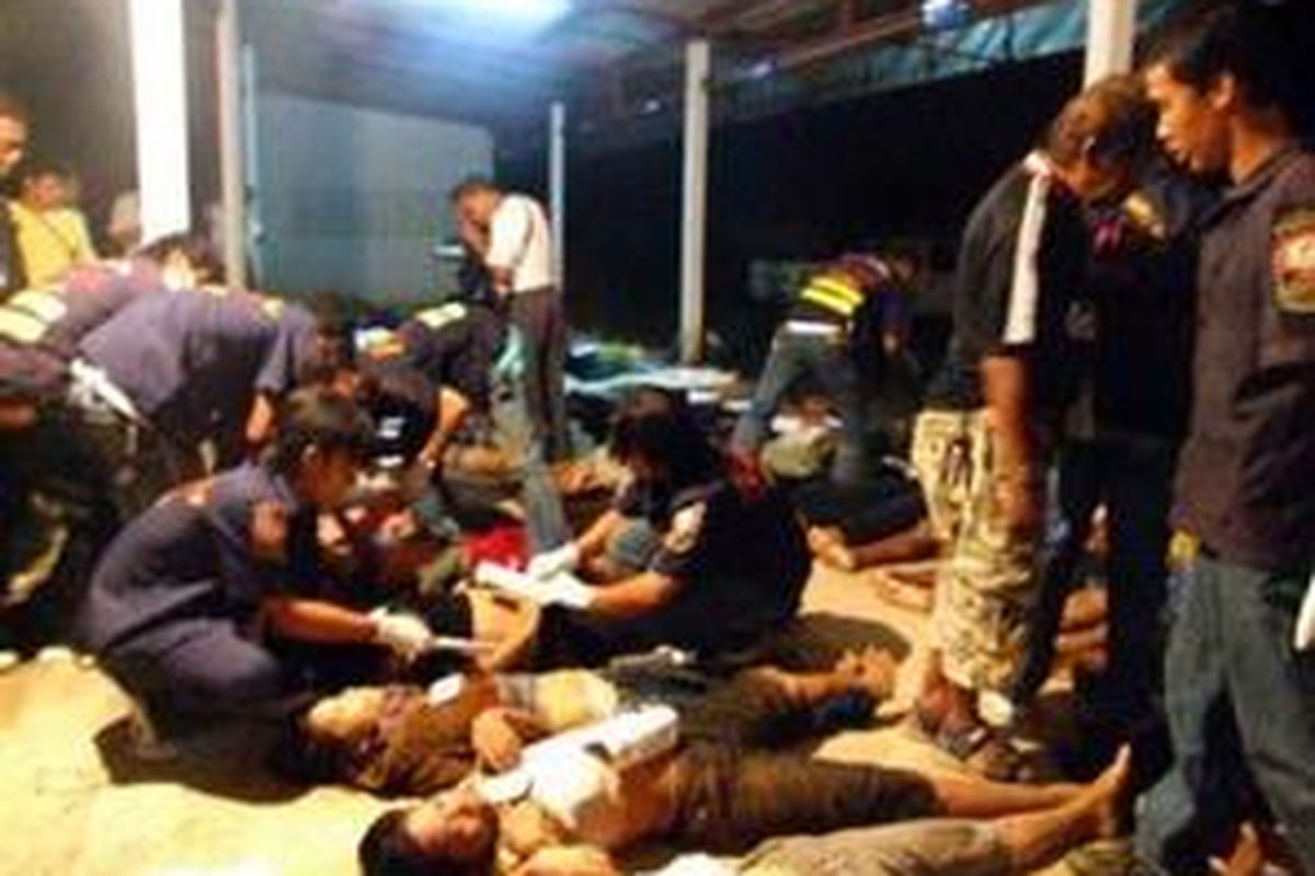 Mayat-mayat para imigran Myanmar diperiksa di rumah sakit Thailand.