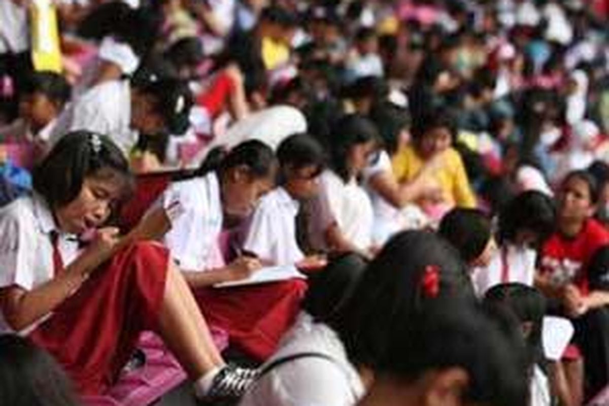Ribuan siswa SD, dari berbagai sekolah di Jabodetabek, mengikuti Try Out Akbar Ujian Nasional untuk pelajar tingkat SD-SMP-SMA yang diselenggarakan salah satu penyelenggara Bimbingan Belajar, di Stadion Utama Gelora Bung Karno, Senayan, Jakarta, Minggu (13/4). 