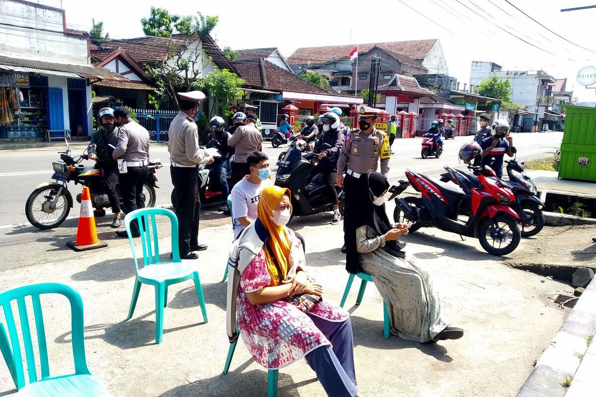 Polisi lalu lintas Polres Blitar menghentikan pengguna jalan yang melintas di Jalan Kusumabangsa, Kanigoro, Kabupaten Blitar, Jumat (24/12/2021) guna mencari warga yang belum divaksin.