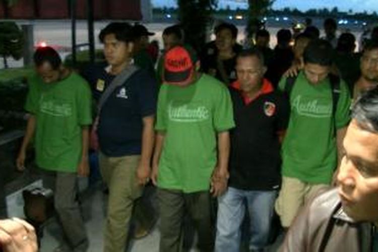 Polisi mengapit sejumlah perompak (berbaju hijau)saat tiba di bandara Tjilik Riwut, Palangkaraya