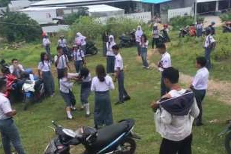 Dua siswi SMA 1 Baubau sedang berkelahi dan direkam serta ditonton oleh teman-temannya.