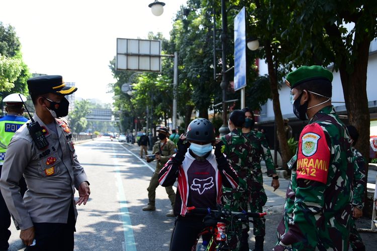 Petugas terlihat melakukan penindakan kepada masyarakat yang tidak menggunakan masker saat PPKM darurat pertama di, Jalan Merdeka, Kota Bandung, Sabtu (3/7/2021).