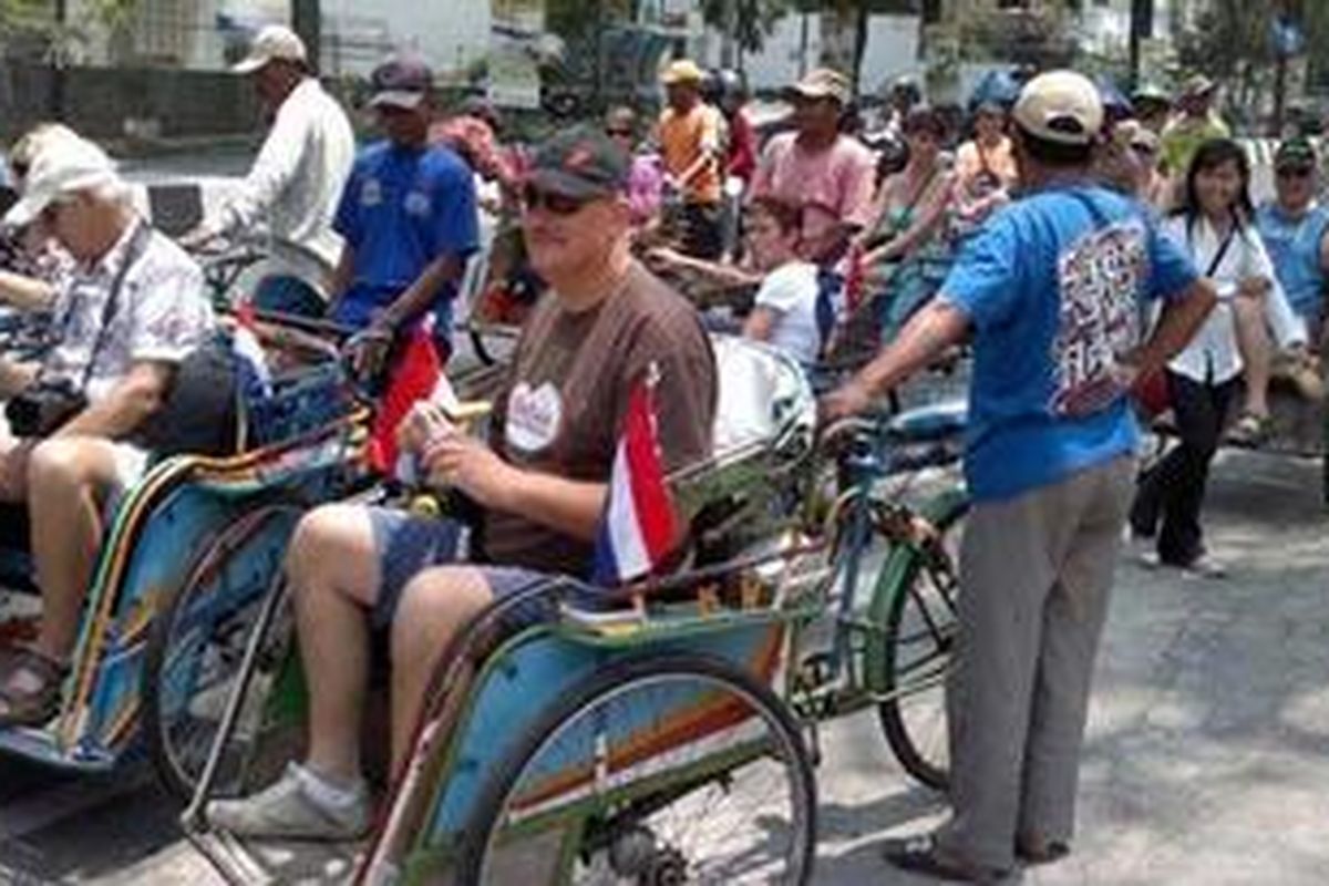 Turis menggunakan becak di Kota Malang, Jatim.