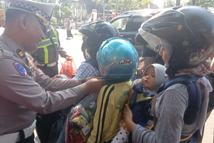 Petugas dari Satlantas Polres Jombang, Jawa Timur, memberikan hadiah berupa helm dan bingkisan kepada anak-anak dalam Operasi Patuh Semeru 2025, Rabu (23/7/2025).