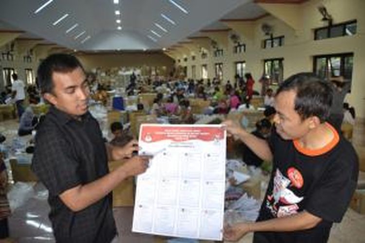 Petugas KPU Polman, Hasriawan dan Staf Panwaslu Polman, Yusran memperlihatkan surat suara untuk DPRD Provinsi Dapil 5 Mamuju yang ditemukan saat proses pelipatan, Minggu (9/3/2014).