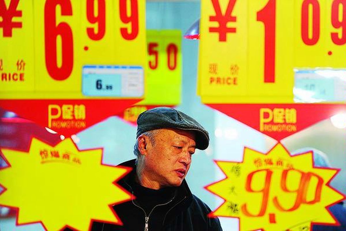 Seorang pembeli berjalan melewati deretan harga barang di sebuah pasar di Hefei, Provinsi Anhui, China, Kamis (12/1). Inflasi China yang melambung sedikit melemah pada Desember, memberi ruang kepada Beijing untuk menstimulasi pertumbuhan ekonomi yang melemah.