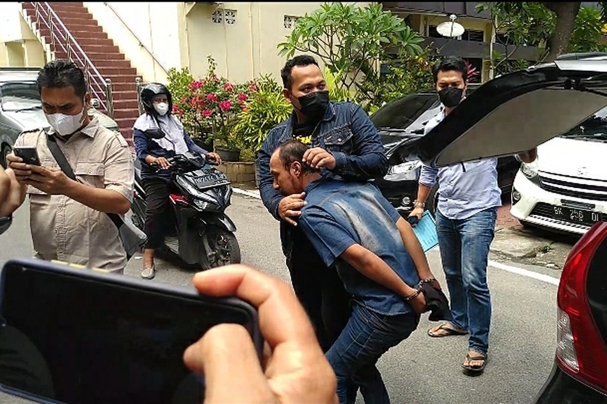 Tersangka GS (33) saat turun dari mobil di Mapolrestabes Medan pada Rabu (16/2/2022) siang. Pelaku mengaku sudah 5 kali menganiaya ibu kandungnya sebulan terakhir.